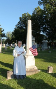 Katherine Layton places a marker and flag on the grave of Gideon D. Williams.